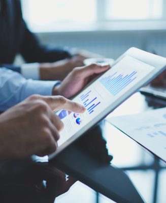Image of businessperson pointing at document in touchpad at meeting